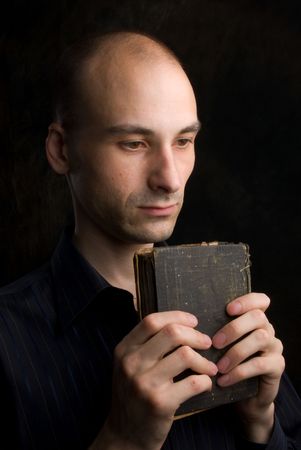 Low key portrait of young man praying