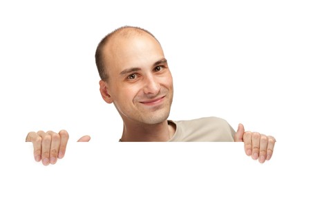 handsome young man peeping over a blank billboardの写真素材