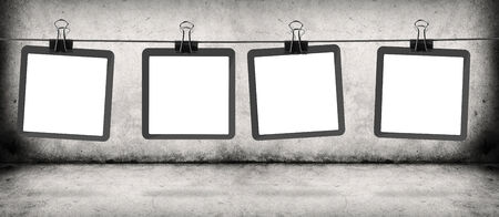 frames on the rope hanging over gray concrete wall and floorの写真素材