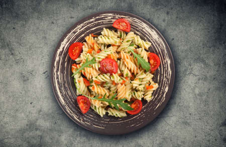 Fusilli pasta with tomato sauce, basil and arugulaの写真素材