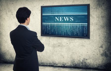 business man looking on monitor with online newsの写真素材