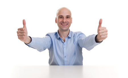 Smiling young business man thumbs up. isolated over whiteの写真素材