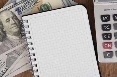 calculator and notepad lying on banknotes close upの写真素材
