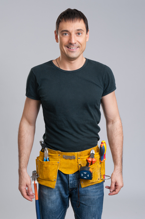 portrait of confident smiling handyman isolated on grayの写真素材