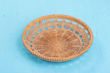 Empty fruit wicker basket bowl. blue background, top viewの写真素材