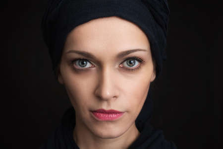 Portrait of a young girl with clean skin on a black background close-up.の写真素材