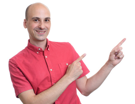 Handsome bald man in red shirt pointing to copy space. Isolated on whiteの写真素材