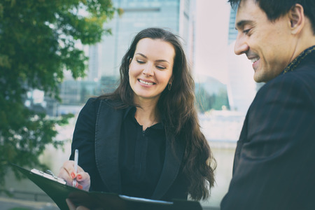 Two business people looking at papers and sign an agreementの写真素材