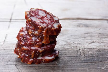 slices of Salami on wooden background close up.の写真素材