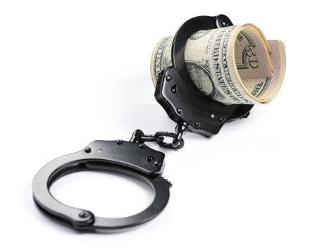 Money and handcuffs isolated on white backgroundの写真素材