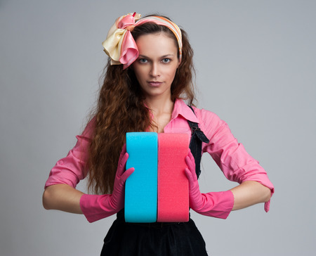 housewife wearing rubber gloves and holding an cleaning sponges