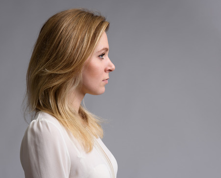profile portrait of a beautiful blonde woman over gray backgroundの写真素材