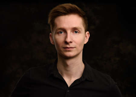 handsome young man studio portrait over black backgroundの写真素材