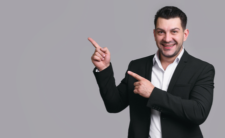 handsome happy businessman pointing finger to copy spaceの写真素材