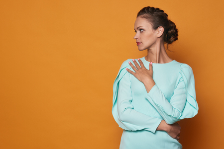 pretty woman over bright orange background with copy spaceの写真素材