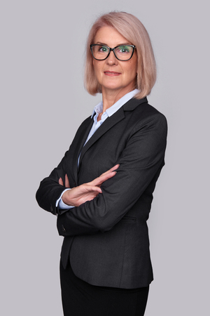 beautiful middle aged business woman wearing glasses isolated on greyの写真素材