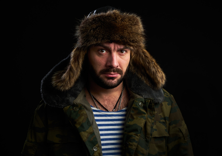 Portrait of bearded man is wearing fur hat and looking at camera. Serious Russian guyの写真素材