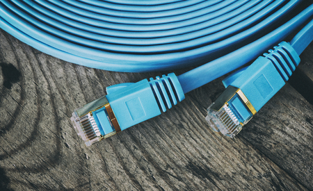 network cable with RJ45 connectors on wooden background