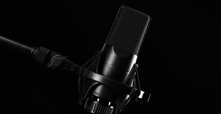 Microphone. Modern sound system equipment for a vocal performer. Mic isolated on black background.の写真素材