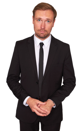 Young businessman standing over white background. Sad business man looking at camera. Isolatedの写真素材