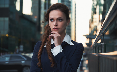 Business woman thinking and looking away in the city streetの写真素材