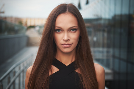 Beautiful woman face. Cute girl with long hair on the street in the cityの写真素材