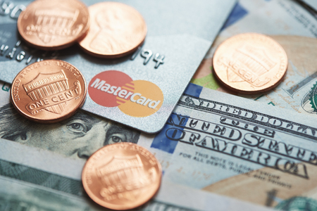Moscow, Russia - September 08, 2018: Mastercard credit plastic card with usa moneyのeditorial素材