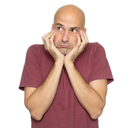 Thoughtful middle aged bald man thinking. Sad guy looking up. Isolated on white
