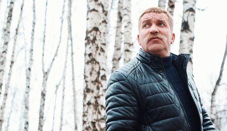 Man is wearing winter jacket in the parkの写真素材