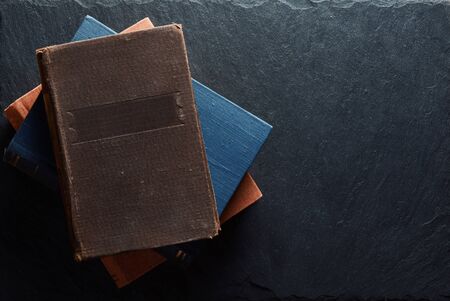 Old hardcover books on a stone background. Top viewの写真素材