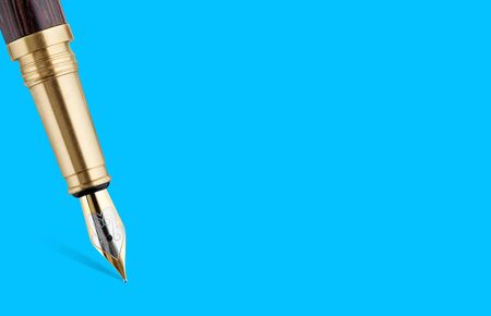 Golden fountain writing pen isolated on a blue background with clipping pathの写真素材