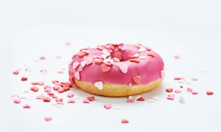 pink glazed doughnuts with sprinkles on white backgroundの写真素材