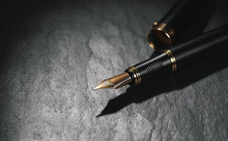 Old golden fountain pen on a black backgroundの写真素材