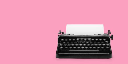 typewriter with paper sheet on pink background. Space for your text
