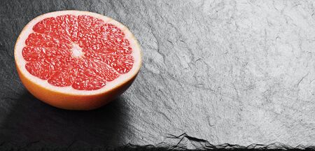 half of a grapefruit on a stone background.の写真素材