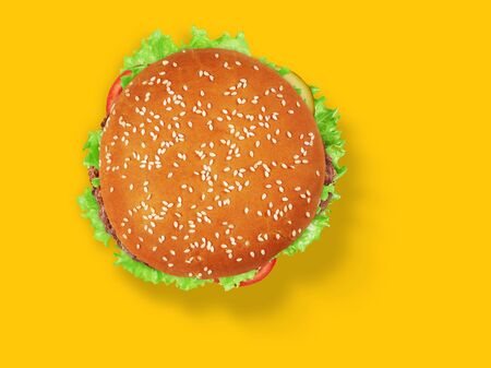 fresh tasty burger on yellow background. Top view.の写真素材