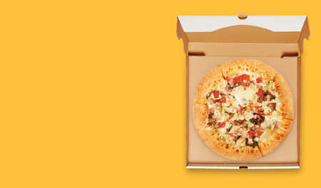 box with cheese pizza isolated on yellow background top view.の写真素材