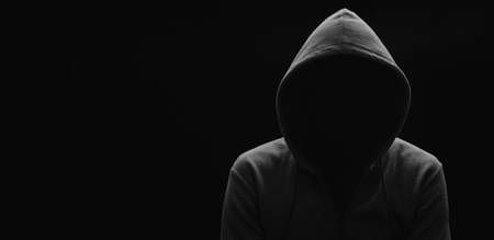 dark mysterious man in a hoodie is hiding his face, hacker, anonymous.の写真素材