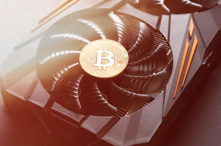 Bitcoin coin on a graphic card. Mining cryptocurrency. Blockchain technology