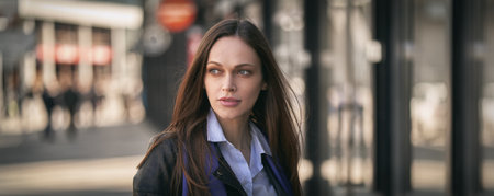 Pretty brunette woman is wearing casual clothes on a city street