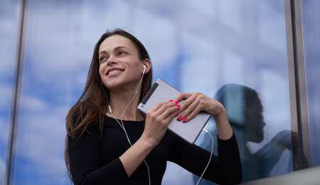 woman is listening to music on phone. Outdoors portrait