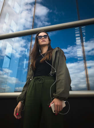 woman is listening to music on phone. Outdoors portraitの写真素材