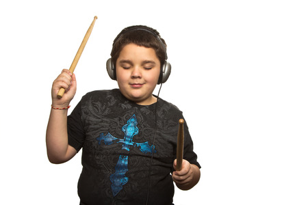 Boy with headphones and drumsticks isolated on white の写真素材
