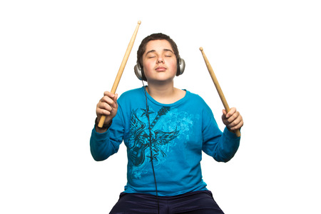 Boy with headphones and drumsticks isolated on white の写真素材