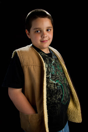 Boy wearing brown vest on black backgroundの写真素材