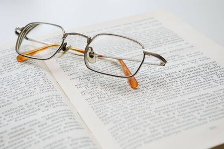 glasses on  an open bookの写真素材