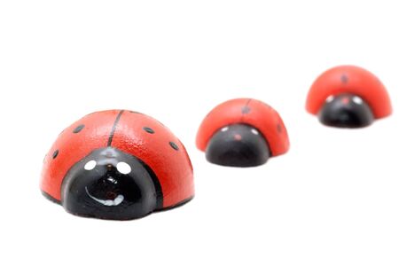 three  toy ladybugs  isolated on white (diminishing perspective)の写真素材