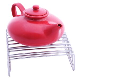 red ceramic teapot on a grillの写真素材