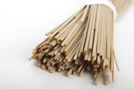 bunch of raw soba noodles laying over white backgroundの写真素材