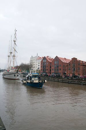 KLAIPEDA, LITHUANIA  NOVEMBER 10: Klaipeda city symbol barquentine "Meridianas"  passes old historical warehouses on way to the major overhaul  on November 10, 2012 in Klaipeda.のeditorial素材